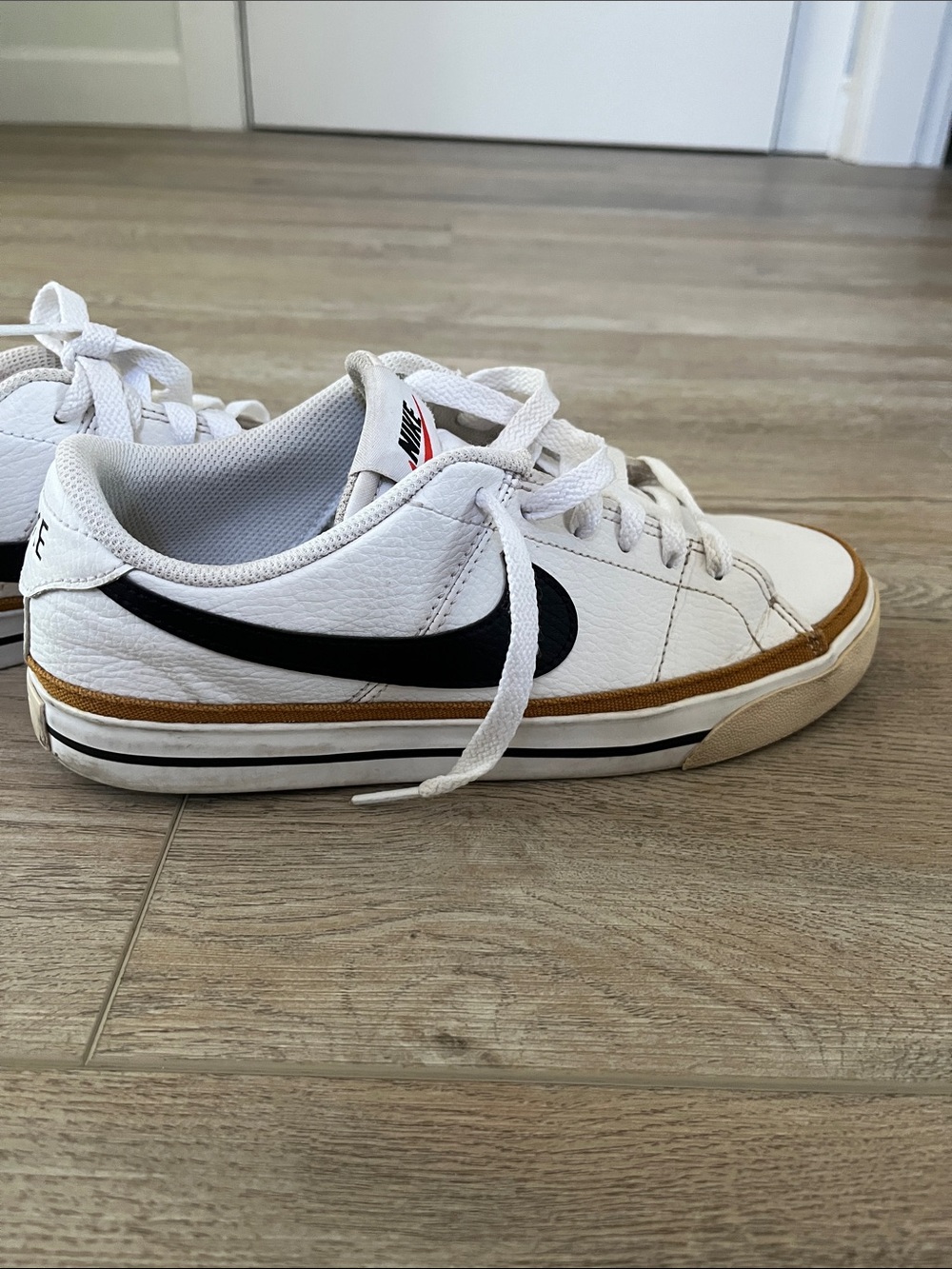 Nike White Low-Top Sneakers with Black Swoosh and Brown Trim